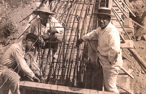 Tres trabajadores preparando una canalización para abastecimiento de agua en los años veinte