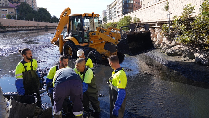 Operarios realizando tareas de limpieza de lodos esta mañana en el río Guadalmedina